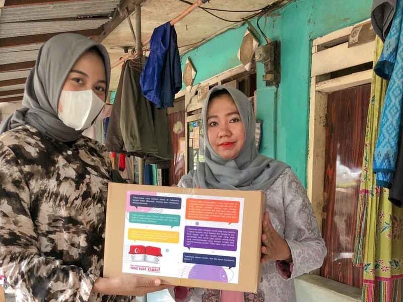 Volunteer handing a sembako (staple food) package to a community member as part of Solve Education’s “Solve Corona” campaign